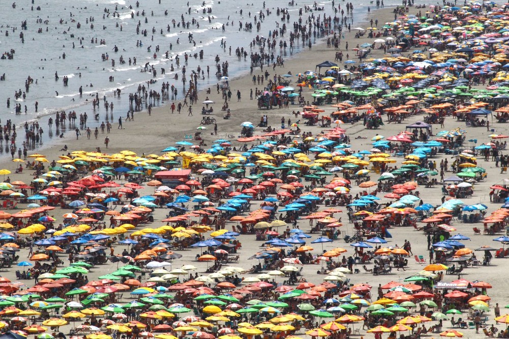 Turistas atrasam volta para casa e lotam praias do litoral de SP em dia de sol e muito calor