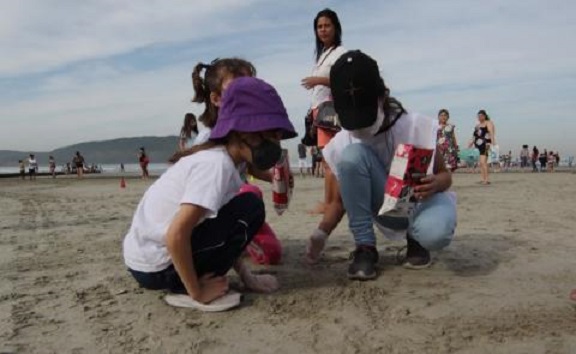 Estudantes de Santos dão aula de consciência ambiental e ajudam a limpar praia
