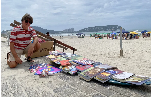Homem distribui livros em troca de sorrisos após ‘sonho revelador’ e faz sucesso em praia do litoral de SP