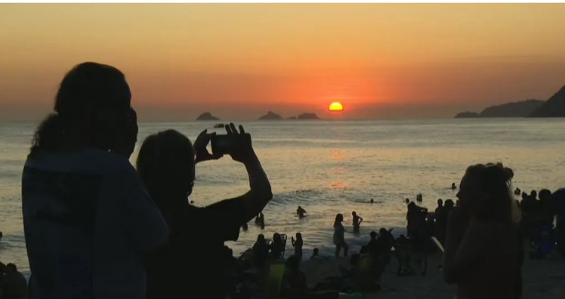 Dia típico de verão carioca tem Arpoador com praia lotada até de noite e pôr do sol sob aplausos